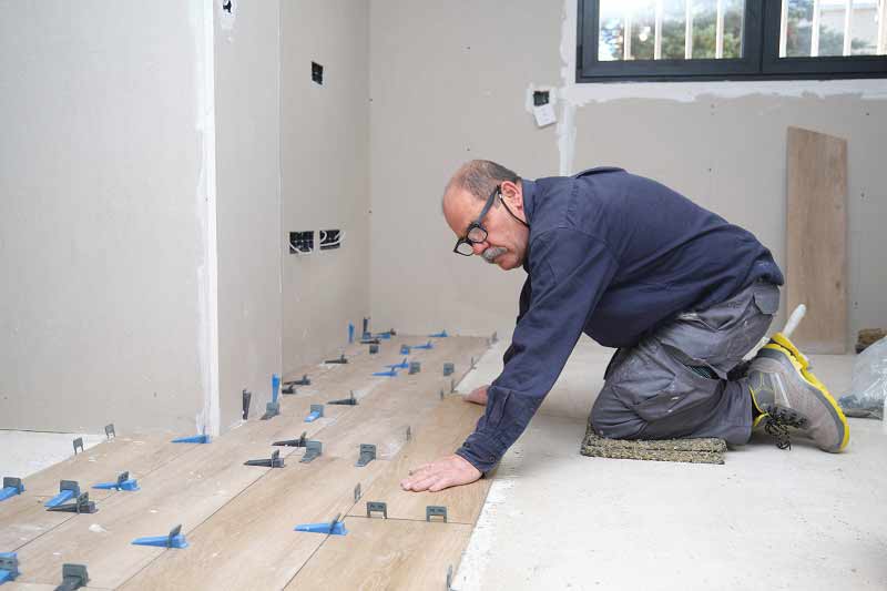 Floorlayer working and kneeling on the floor