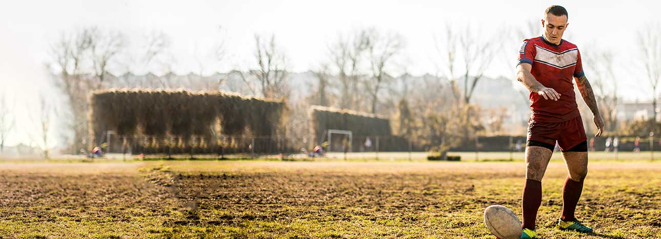 A young man about to kick a rugby ball