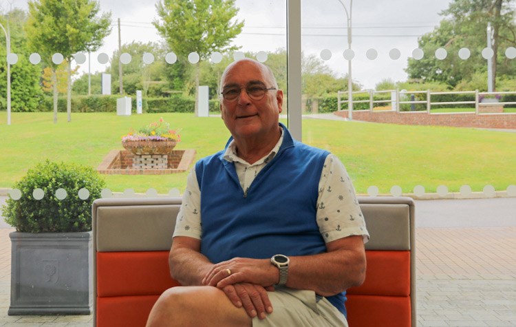 A smiling Chris Setterfield sitting comfortably in one of the patient waiting areas at Benenden Hospital.