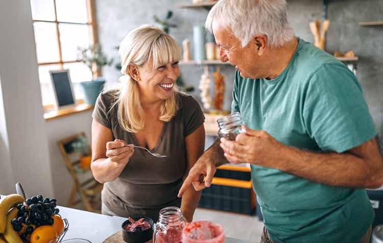 Senior man is talking to his wife in the kitchen. 