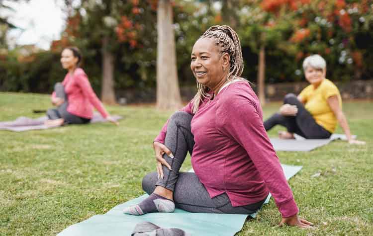 Women doing yoga exercises in a park.