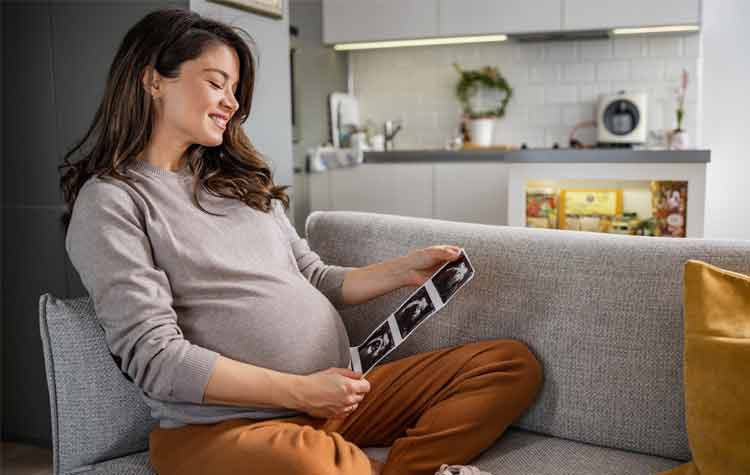 Portrait of a pregnant woman, who is about to give birth, looking at an ultrasound scan.