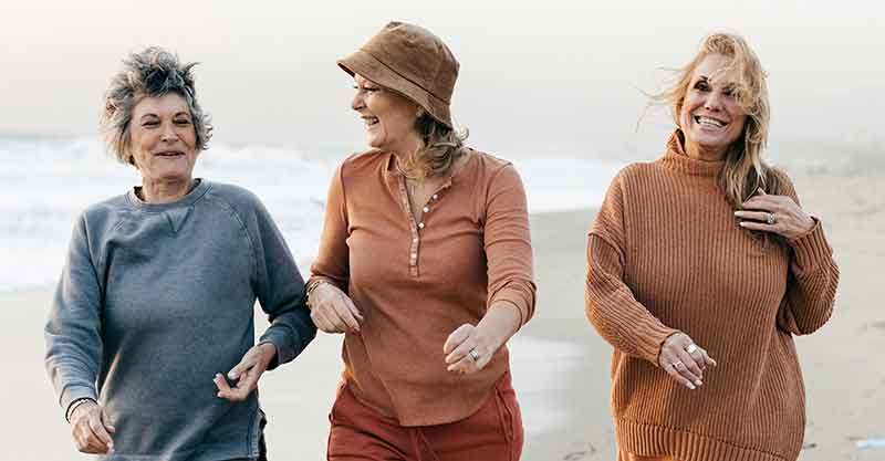 Three women walking on a beach