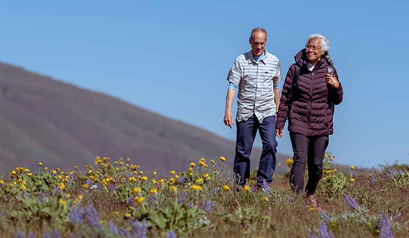 Older couple walking in the hills