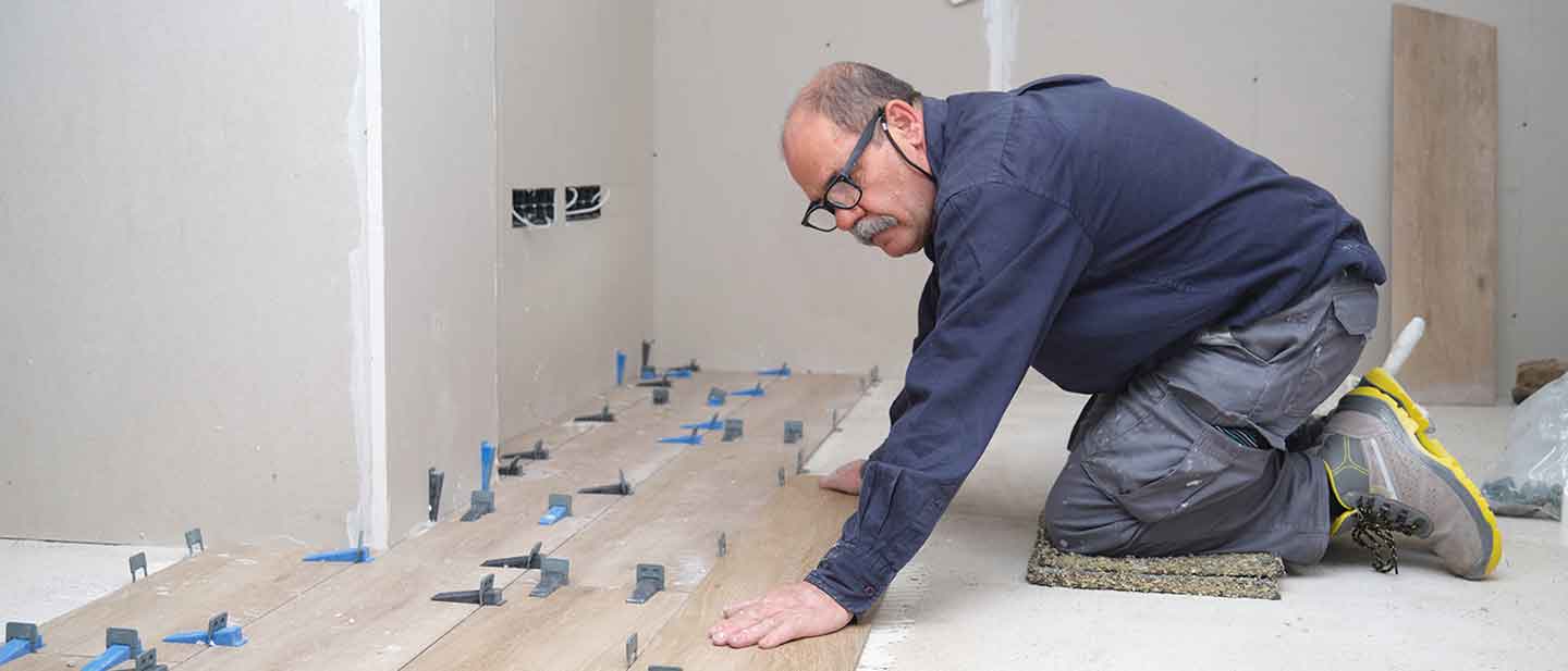 Floor layer working on his knees