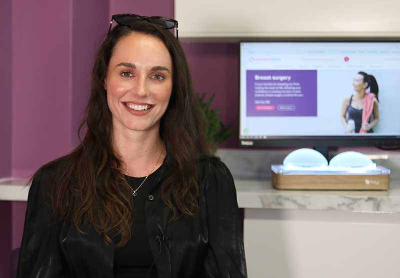 Olivia sitting in front of a screen displaying the hospital website