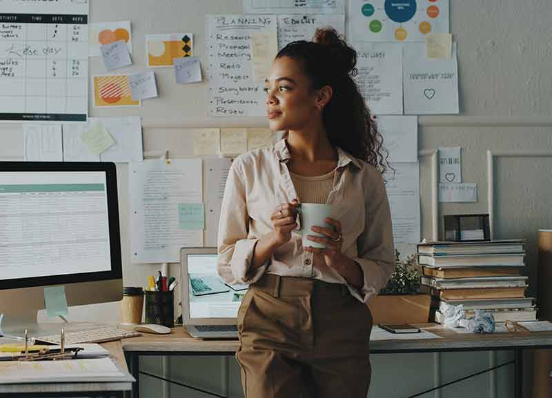 A woman standing by a PC