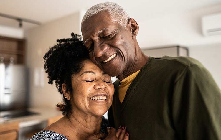 Senior couple embracing each other at home