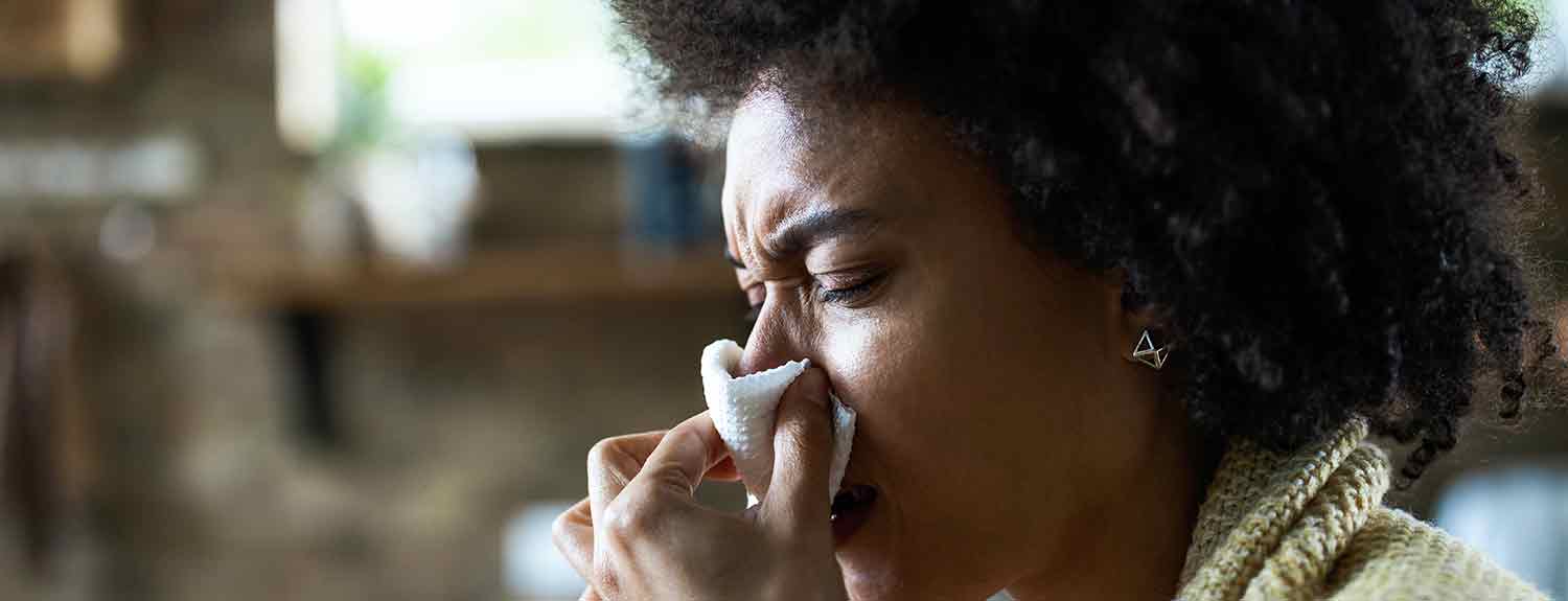 Woman blowing her nose