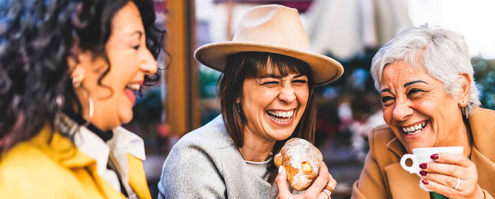 Three women talking over coffee and cake