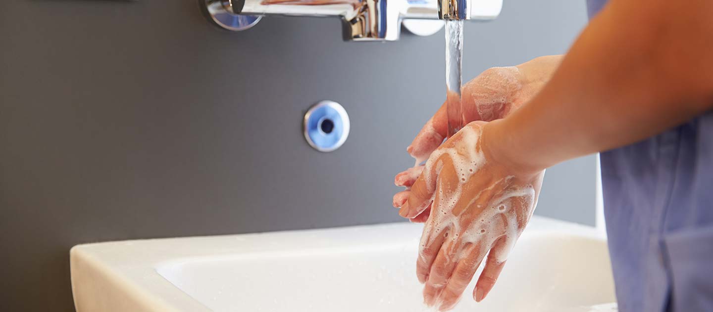 A clinical staff member washing their hands