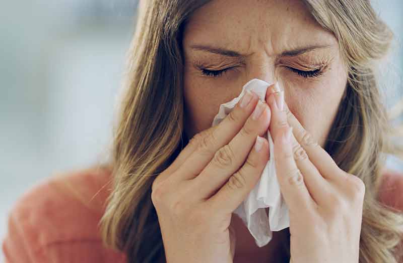 Woman blowing her nose