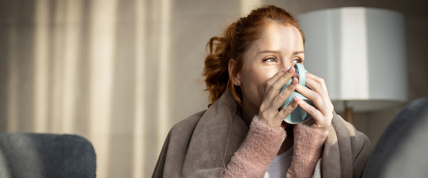 Woman drinking a hot drink on the sofa
