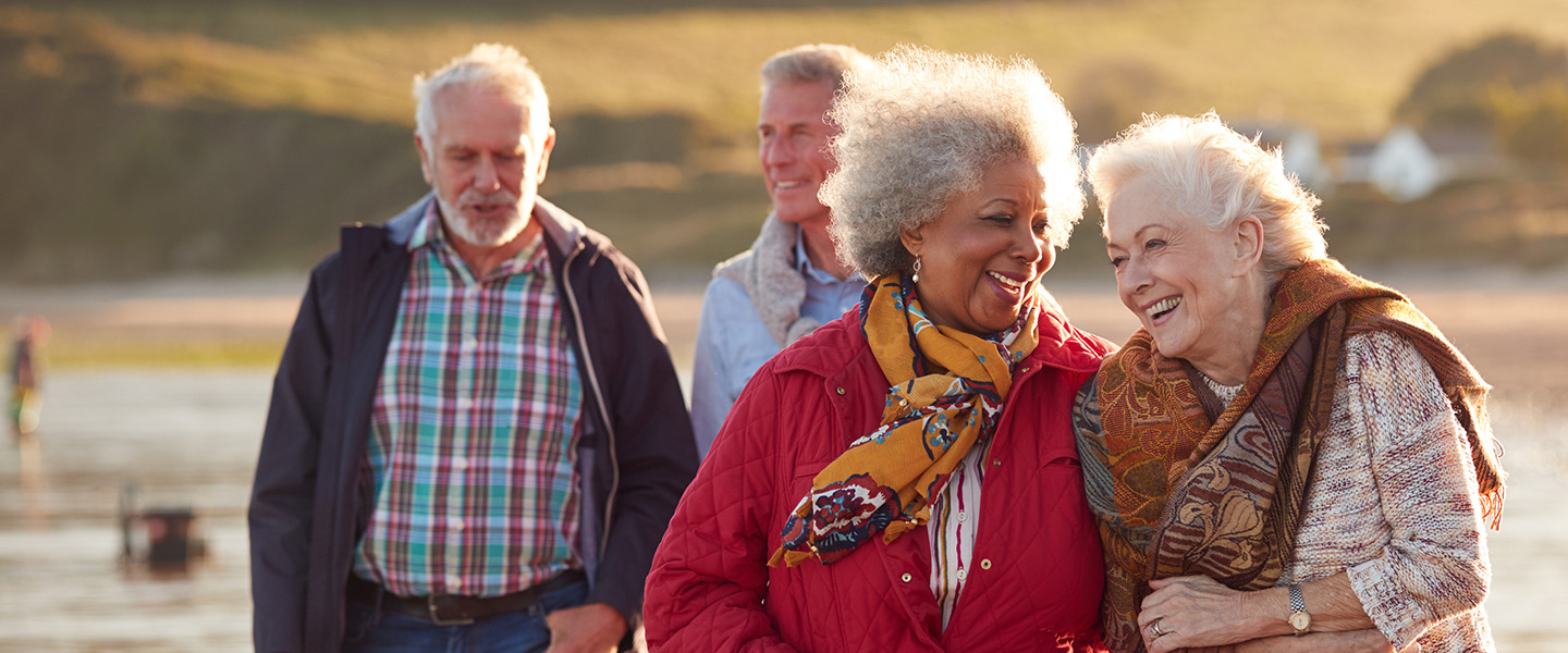 Two elderly couples walking on the beach