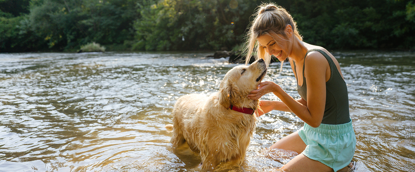 Woman and her dog in a river