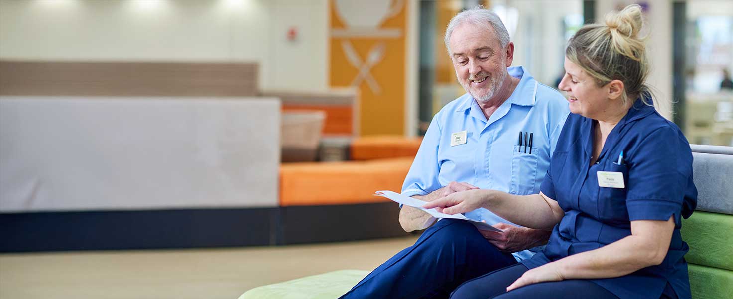 A nurse talking to another member of staff
