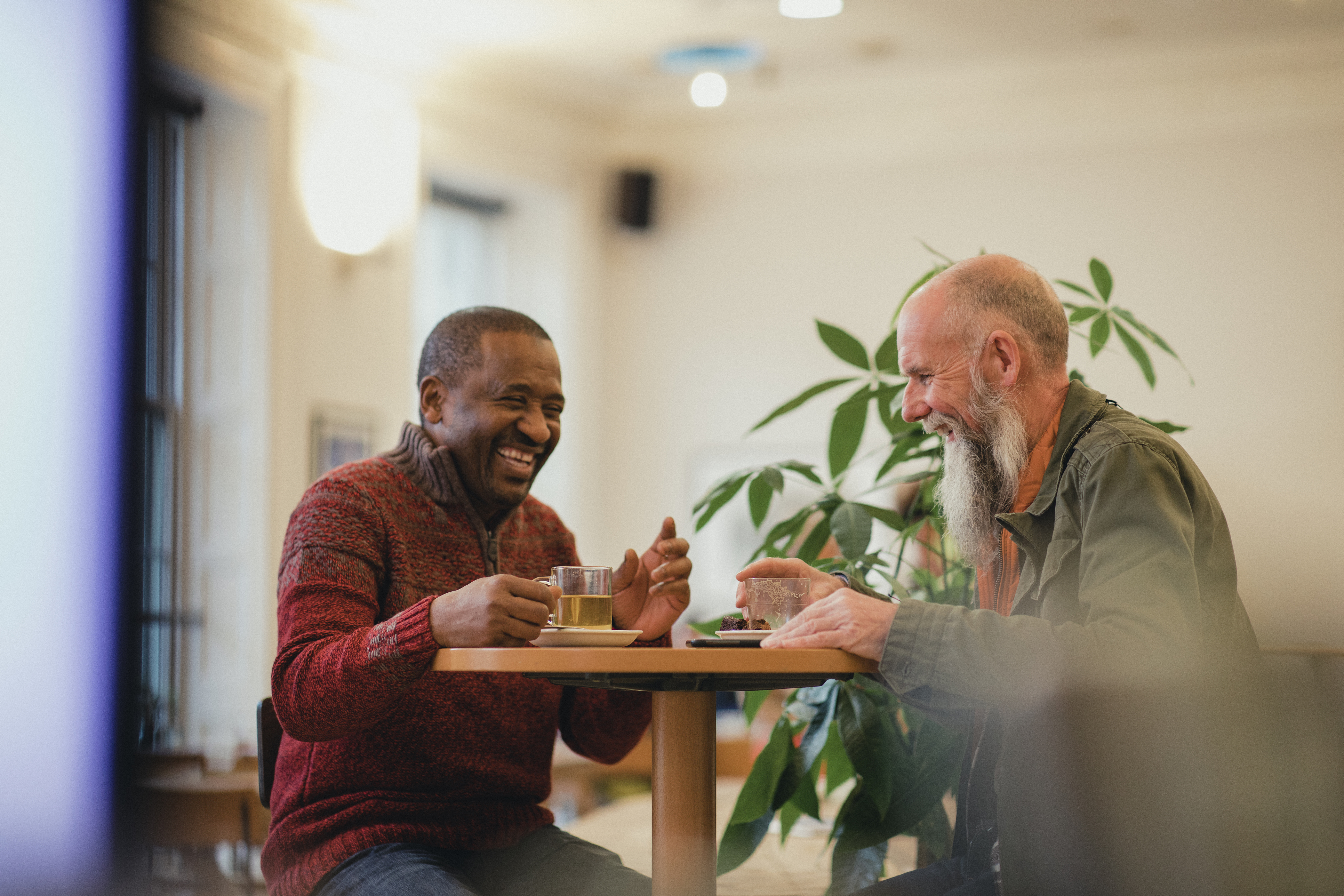 Two men enjoying hot drinks in a cafe
