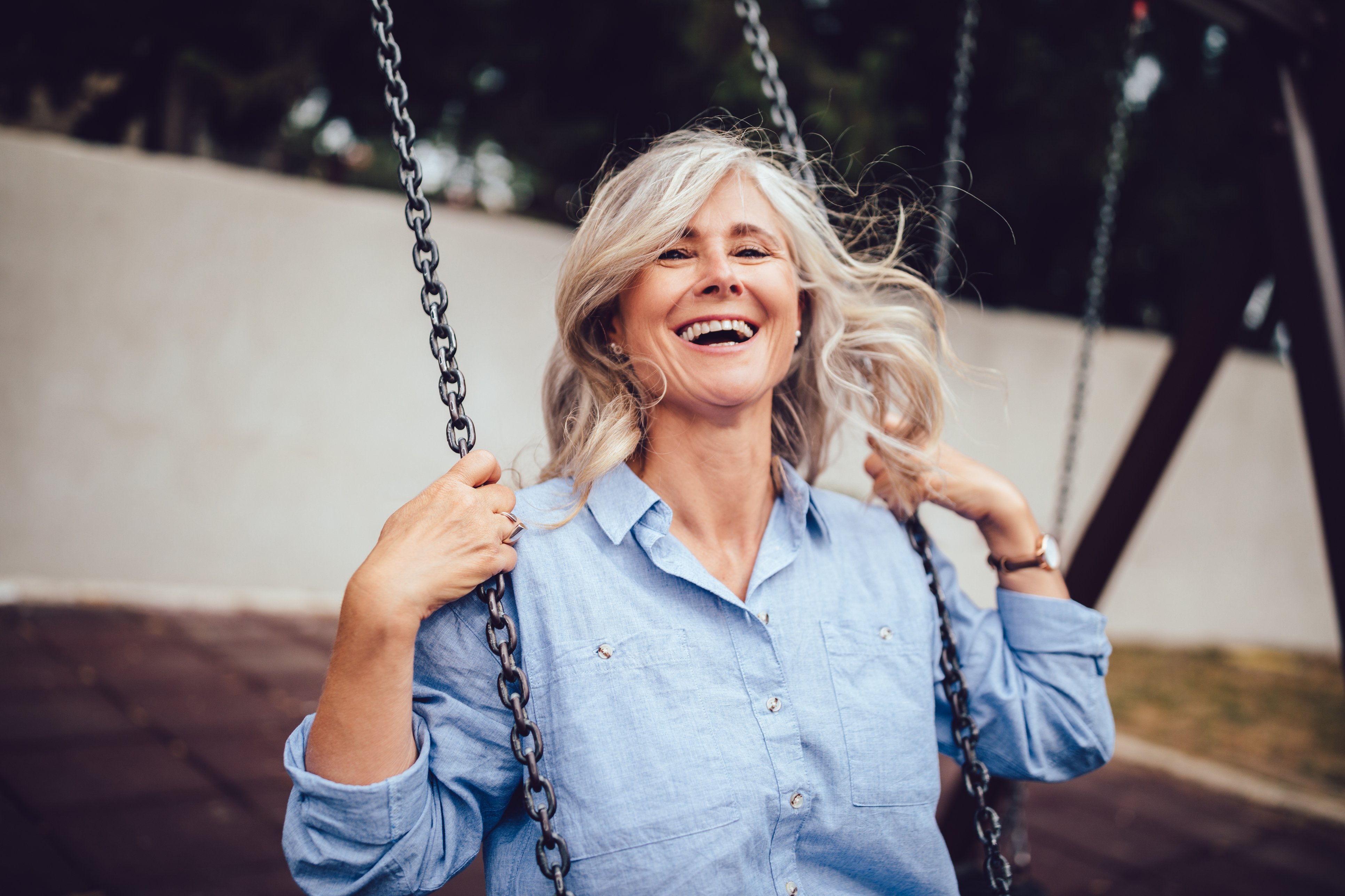 Elderly lady smiling on a swing