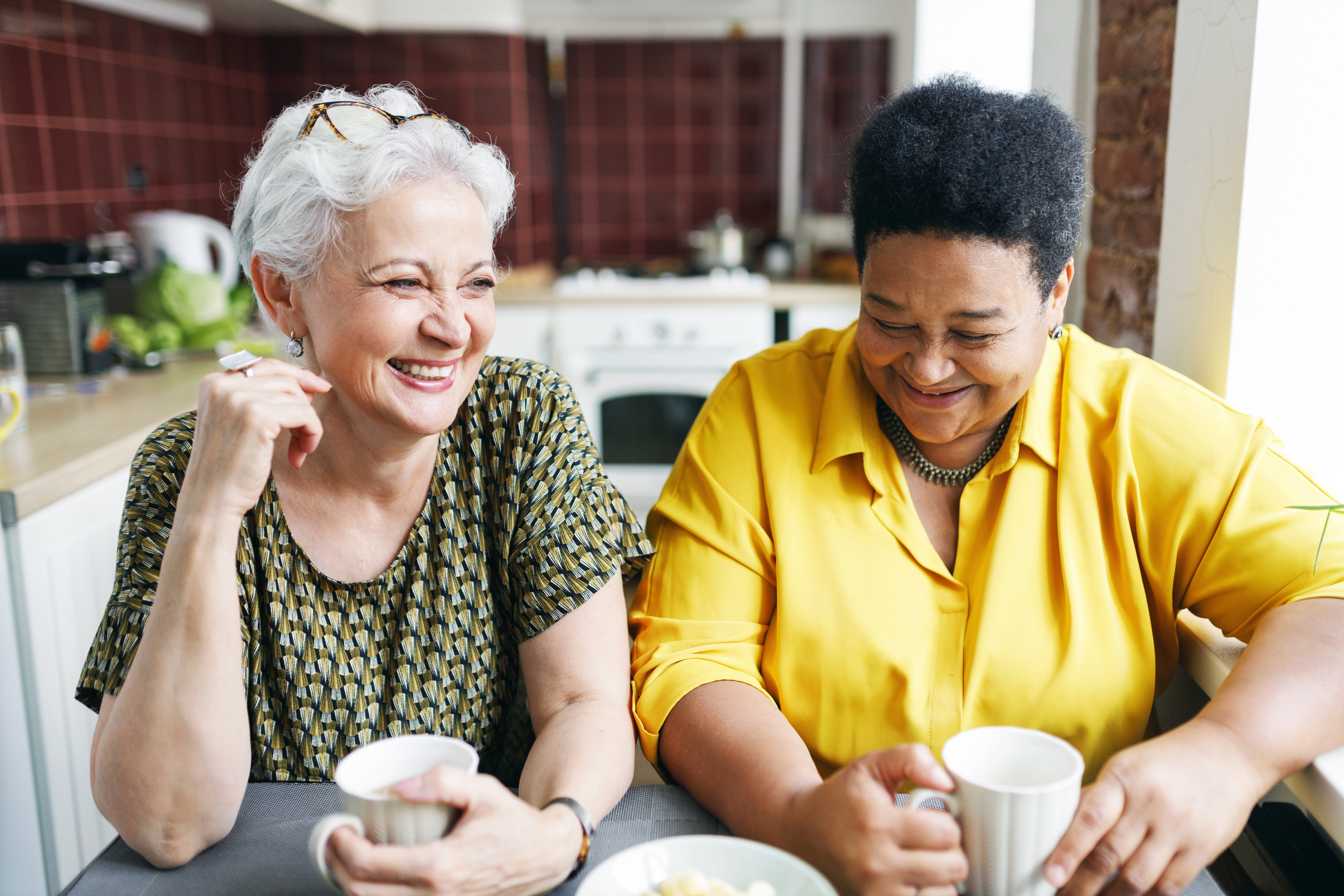 Two women laughing in a kitchen