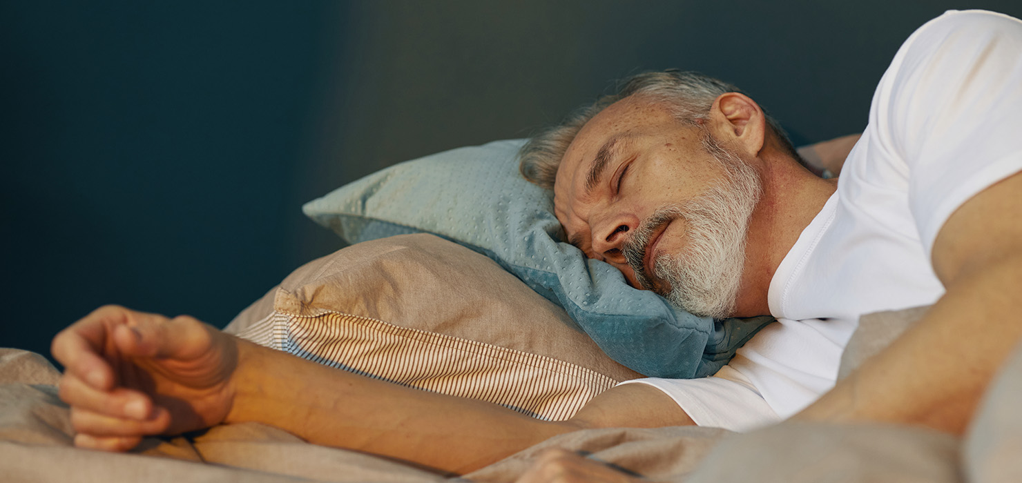Elderly man sleeping in bed