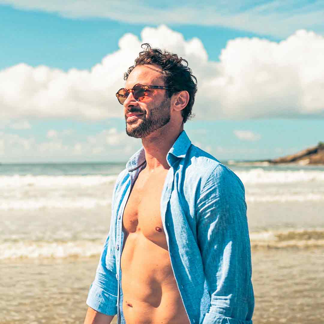 Man on a beach in a blue shirt