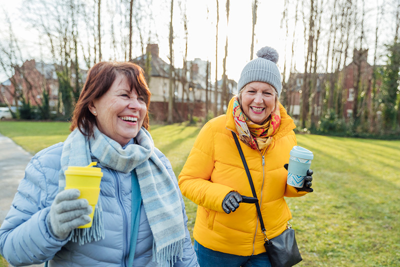 Two smiling elderly women on a walk