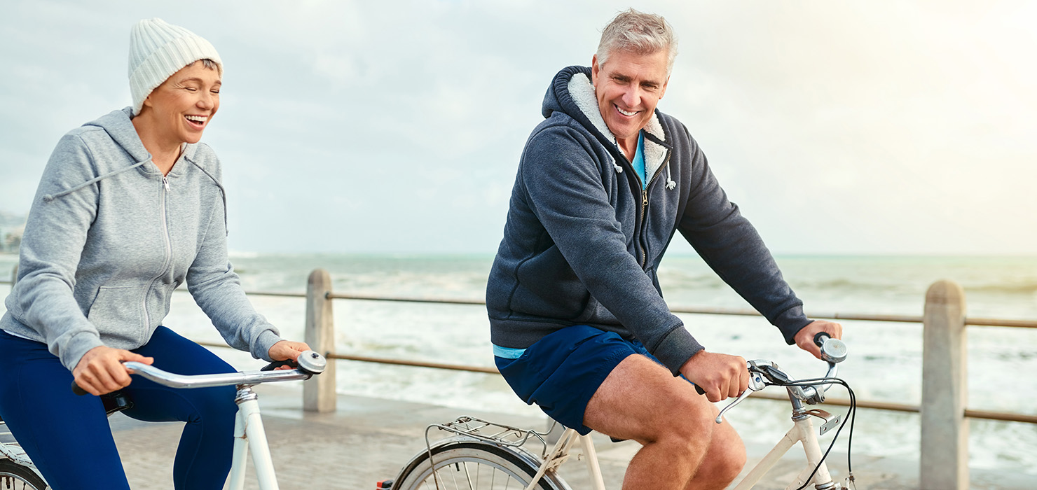 Couple cycling by the sea