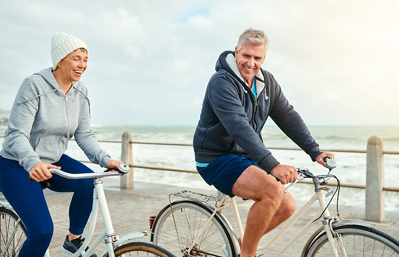 Couple cycling by the sea