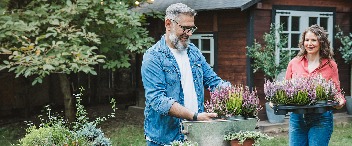 Couple potting plants in their garden