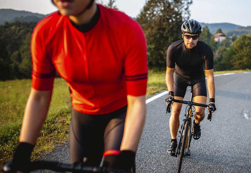 Two men cycling up a hill