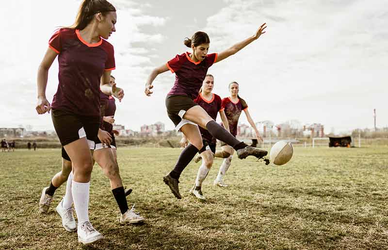 A woman kicking a rugby ball