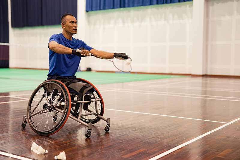 An athlete playing wheelchair badminton