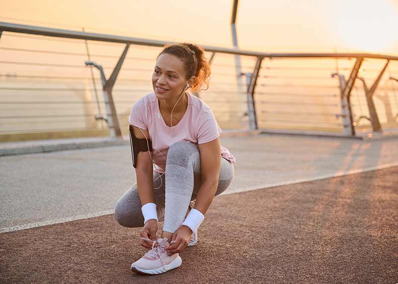 A woman tying her laces after running