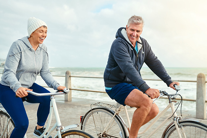 Mature couple cycling on the sea front