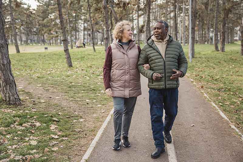 Two people walking through a park