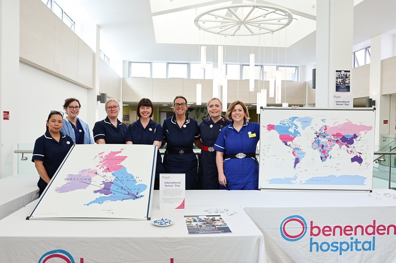 A group of nurses holding large maps in a hospital atrium