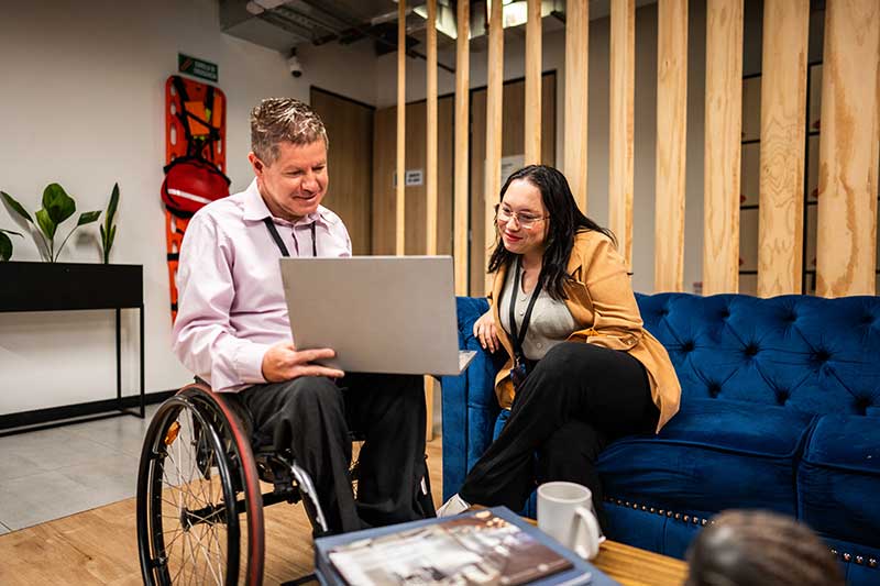 Two colleagues looking at a laptop
