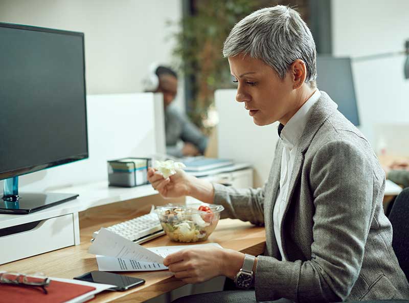 A woman eating her lunch while working