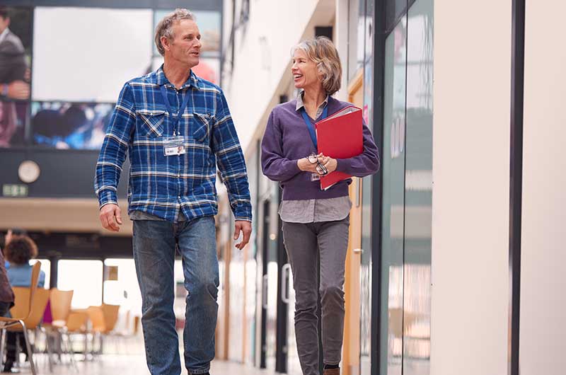 Two people at work walking and talking
