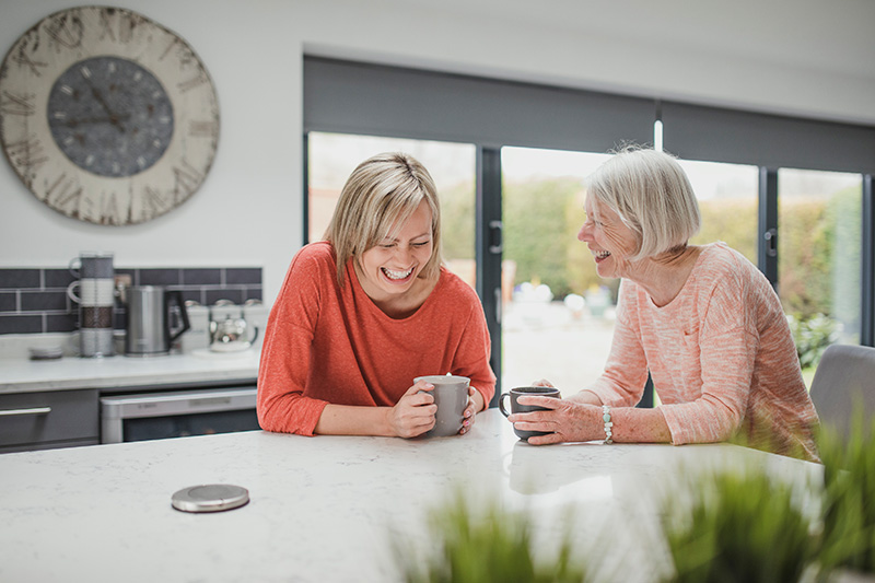 Two women laughing in their kitchen