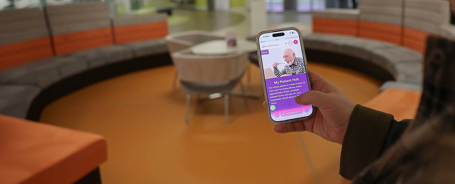 A person in the hospital Atrium holding a mobile phone