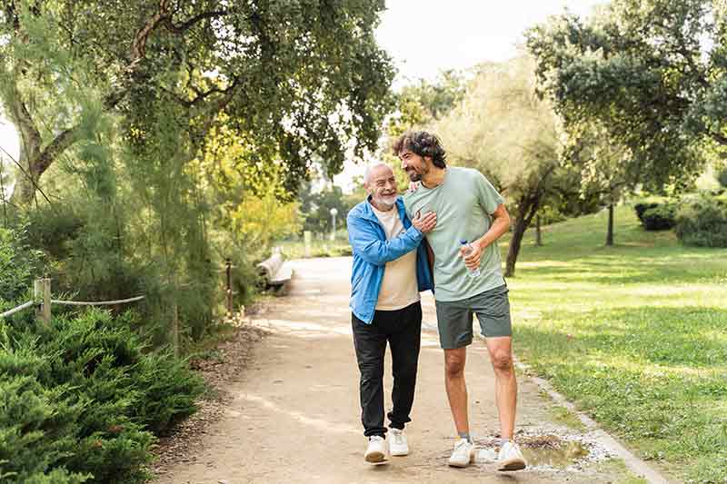 A man and his dad walking through a park
