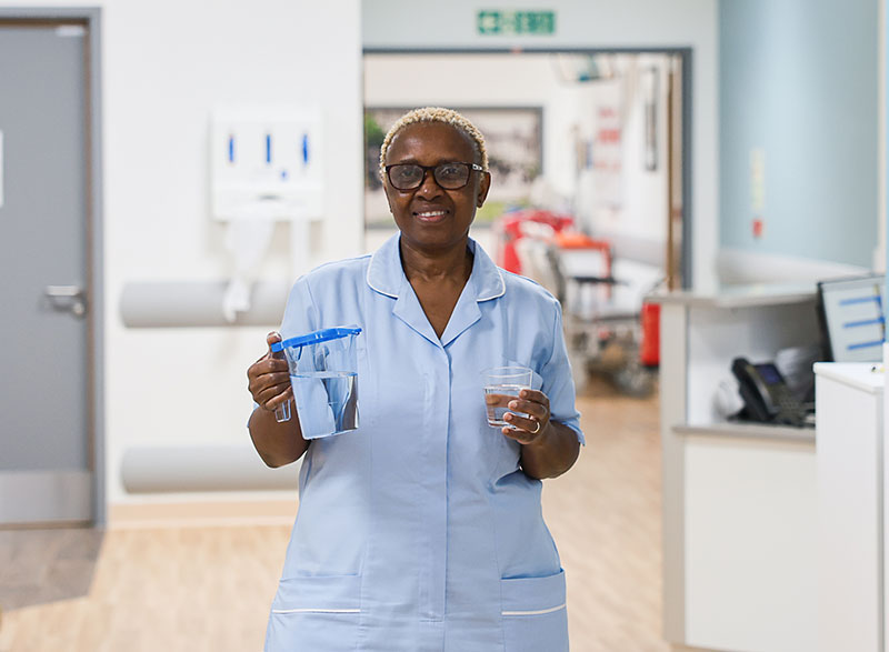 A nurse holding a jug of water