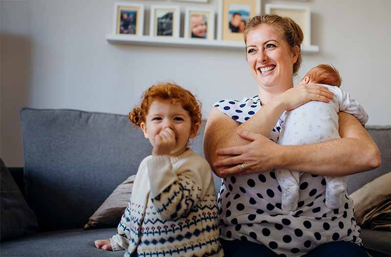 A woman with a young baby and toddler