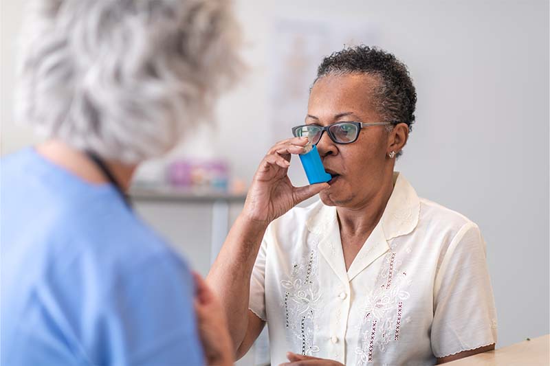 Lady using an asthma inhaler